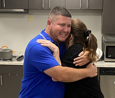 Instructor, Connie Michaels and client pictured hugging during a kitchen instruction.