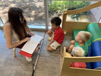 Jazmine Nelson reads to young children at the Jordan YMCA using Braille