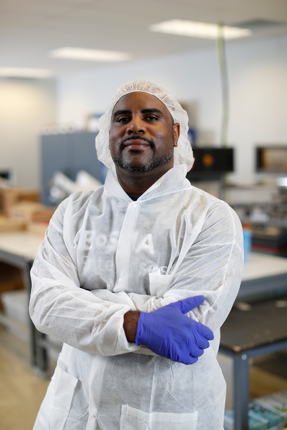 An employee in PPE looking at the camera smiling
